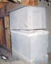 Concrete crawl space support posts in Mitchell that are showing signs of failure as they sink into the earth.