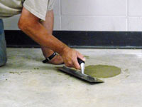 Repairing the cored holes in the concrete slab floor with fresh concrete and cleaning up the Winkler home.