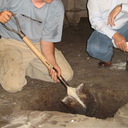 Digging a hole for the engineered fill used in a crawl space support system installation in Thompson