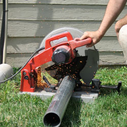 Cutting the support beam for a crawl space jack post outside a Winkler home.