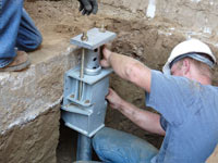 Foundation repair contractors installing the foundation bracket in Portage La Prairie.