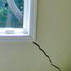 A long, diagonal crack that begins at a window corner of a Reinfeld home