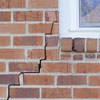 long jagged cracks starting at the corner of a window along a brick wall on a Mitchell home