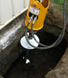 Installing a helical pier during a foundation repair in Selkirk