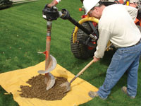Auguring a hole in the earth for a foundation wall repair system in Winkler