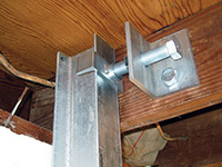 Securing the i-beam system to the top of the floor joist in a foundation wall repair in Winkler.
