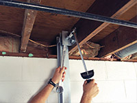 Straightening a foundation wall with the PowerBrace™ i-beam system in a Morden home.