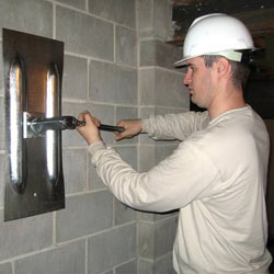 installing a wall anchor to repair an bowing foundation wall in Morden