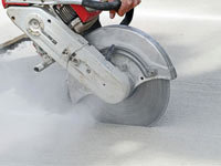 Cutting the driveway for expansion joints during street creep repair in Ste Anne