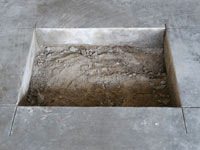 Creating the hole in the garage slab floor during the wall anchor installation in Reinfeld.
