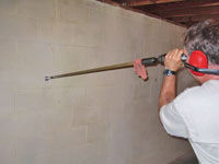 Drilling the hole in the foundation wall for street creep repairs in La Salle